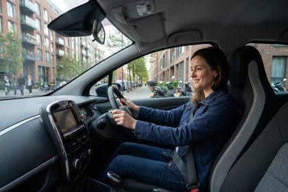Femme souriante dans une voiture électrique en ville