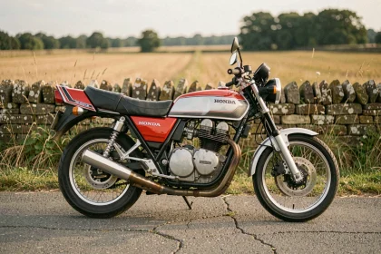 Honda CB 900 F rouge des années 1980 garée sur une route de campagne française avec mur en pierre sèche