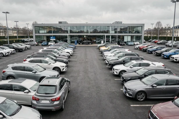 Vue large d'un parc de voitures d'occasion dans les Hauts-de-Seine avec showroom moderne en arrière-plan