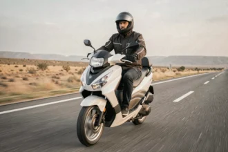Scooter Yamaha XMAX 125 roulant à pleine vitesse sur route ouverte, vue grand angle basse